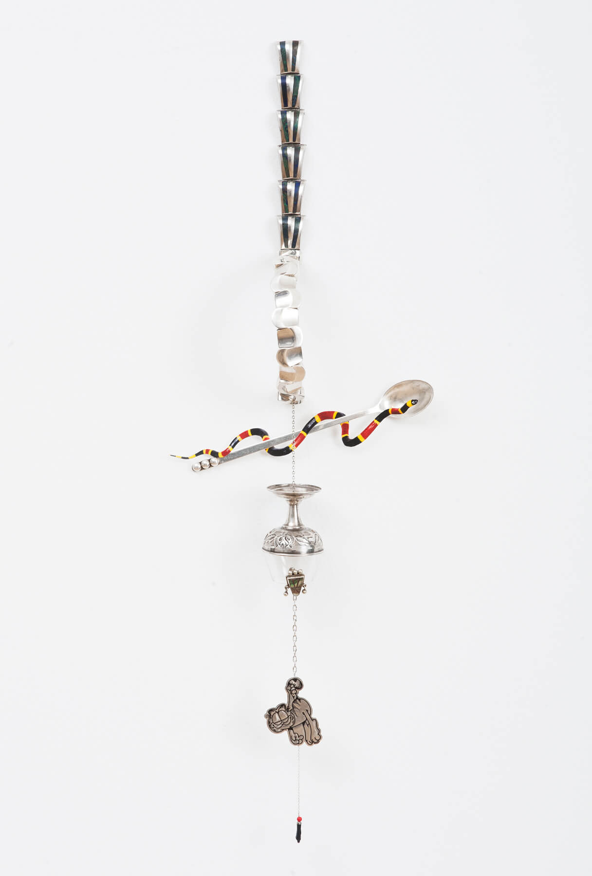 Livia Corona Benjamin
                                        'Rx (Red and Yellow Kills a Fellow)', 2015
                                         26 x 9 x 3 Inches
                                        Antonio Pineda Silver Thumbprint Bracelet, Enrique Ledesma Silver and green Lapis Lazuli bracelet, silver spoon, photographic print, silver and glass goblet, abalone shell earring, Garfield pendant, silver chains, plastic figa
                                        